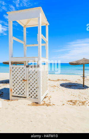 Weiße Holz Rettungsschwimmer und Liegestühle mit Sonnenschirmen am weißen Sandstrand in Villasimius Dorf am Meer, Insel Sardinien, Italien Stockfoto