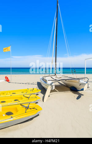 PORTO GIUNCO Strand, Sardinien - 27. Mai 2014: gelbe Kajaks und Katamaran Boot am Strand von Porto Giunco, Insel Sardinien, Italien Stockfoto