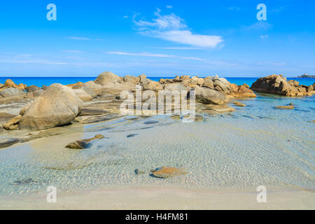 Felsen in flache kristallklare türkisfarbene Meerwasser von Porto Giunco Beach, Insel Sardinien, Italien Stockfoto