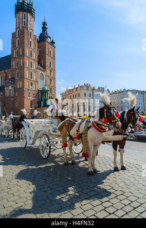 Krakau, Polen - SEP 7, 2014: Pferdewagen vor Marienkirche am wichtigsten Platz von Krakau Stadt. Einen Ausritt in der Kutsche ist sehr beliebt bei den Touristen in Krakau. Stockfoto