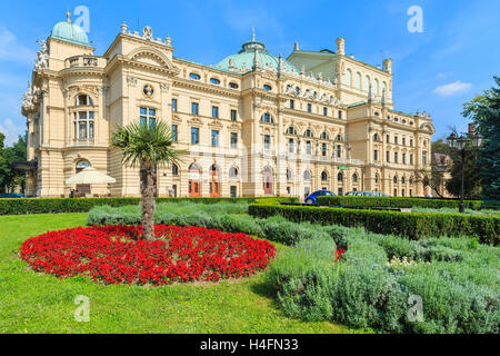 Rote Blumen mit Palme vor Slowackiego Theatergebäude in Krakau, Polen Stockfoto