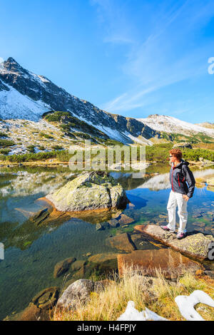 Junge Frau Touristen stehen auf Felsen und blickte am See im Herbst, hohen Tatra, Polen Stockfoto