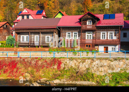 Traditionelle Häuser am Ufer des Flusses Dunajec an sonnigen Herbsttag, Szczawnica, Polen Stockfoto