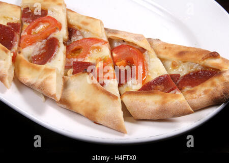 Türkische Pizza (Pide) Türkische Wurst, Tomaten und Cheddar-Käse Stockfoto