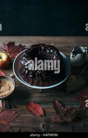 Johannisbrot und Apfel-Gugelhupf mit Schokoladenganache auf eine Kuchenplatte Stockfoto