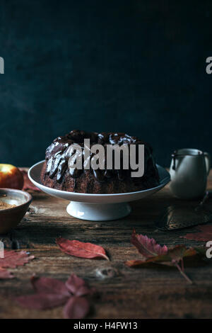 Johannisbrot und Apfel-Gugelhupf mit Schokoladenganache auf eine Kuchenplatte Stockfoto