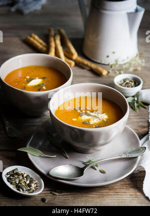 Kürbis Cremesuppe in graue Schalen auf rustikalen Tisch Stockfoto