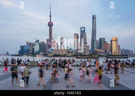 Touristen und Einheimische auf den Bund gegenüber Pudong, Shanghai, China. Stockfoto