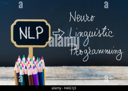 Geschäft Abkürzung NLP Neuro linguistische Programmierung mit Kreide auf hölzernen Mini Tafel Etiketten und Tafel Hintergrund geschrieben. Stockfoto