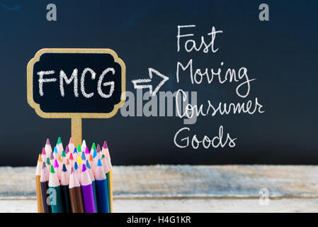 Geschäft Abkürzung FMCG Fast Moving Consumer Goods mit Kreide auf hölzernen Mini Tafel Etiketten und Tafel Hintergrund geschrieben. Stockfoto