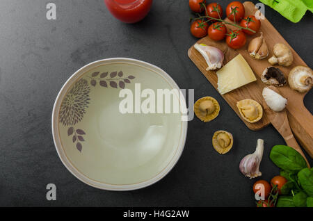 Hausgemachte Tortellini gefüllt, Pilze und Tomaten mit Feta-Käse Stockfoto