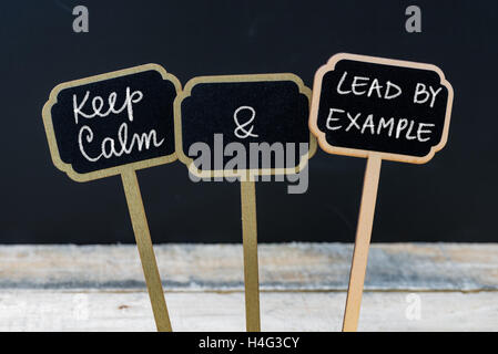 Halten Sie Ruhe und führen durch Beispiel Nachricht auf Etiketten Mini-Tafel mit Kreide geschrieben Stockfoto