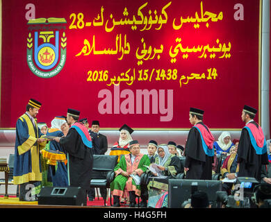 Bandar Seri Begawan, Brunei. 15. Oktober 2016. Brunei Sultan Haji Hassanal Bolkiah (L, vorn) stellt ein Zertifikat an einem Studenten während der Universität Brunei Darussalam (UBD) des 28. Einberufung in die Hauptstadt von Brunei, Bandar Seri Begawan am 15. Oktober 2016. Hassanal Bolkiah, der auch die Kanzlerin der Universität Brunei Darussalam (UBD), präsentiert Zertifikate 1.477 Absolventen während der Einberufung. © Jeffrey Wong/Xinhua/Alamy Live-Nachrichten Stockfoto