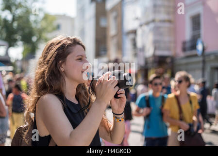 Ein Mädchen mit einer Kamera fotografieren auf einer Straße Stockfoto