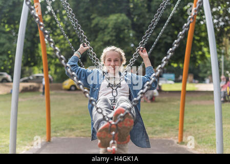 Junges Mädchen auf einer Schaukel in einem park Stockfoto