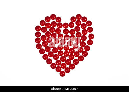 Herzform aus roten Tabletten auf einem weißen Hintergrund symbolisiert Herz Medikamente oder Romantik und Valentinstag Valentin geschaffen Stockfoto