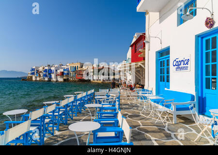 Die Stadt MYKONOS, Griechenland - 15. Mai 2016: Tische des Restaurants auf der Küstenpromenade Insel Mykonos, Griechenland. Stockfoto