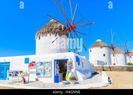 Shop mit touristischen Souvenirs vor berühmten traditionellen Windmühlen auf Mykonos, Kykladen, Griechenland Stockfoto