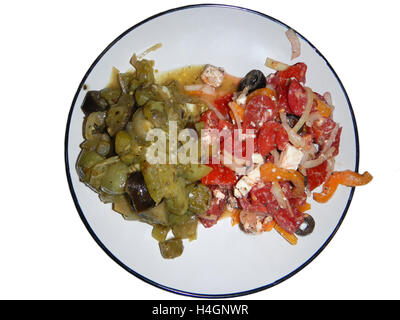 Grüne Tomaten geschmort mit weiße Zwiebel auf eingekreisten Schüssel in der Nähe von bunten Salat mit Käse Feta, rote Tomaten, weiße Zwiebel Stockfoto