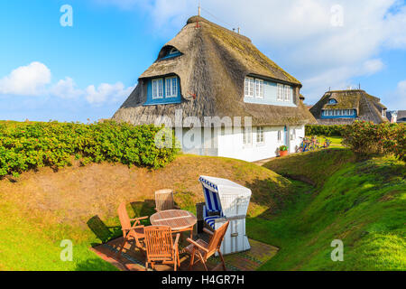 Strandkorb im Garten des typisch friesischen Haus mit Reetdach auf der Insel Sylt, Deutschland Stockfoto