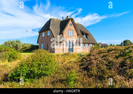 Traditionelle rote Backsteinhaus mit Strohdach auf Wiese in der Nähe von Wenningstedt Dorf auf der Insel Sylt, Deutschland Stockfoto