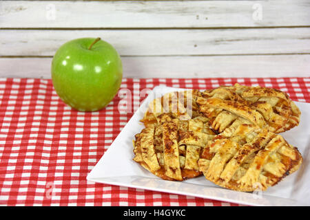 Apfelkuchen Cookies mit grünem Apfel auf rot-weiß karierte Tischdecke Stockfoto