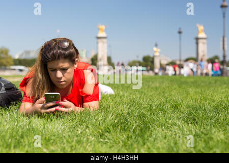 Glückliche Frau in Paris überprüfen ihr Smartphone News Stockfoto