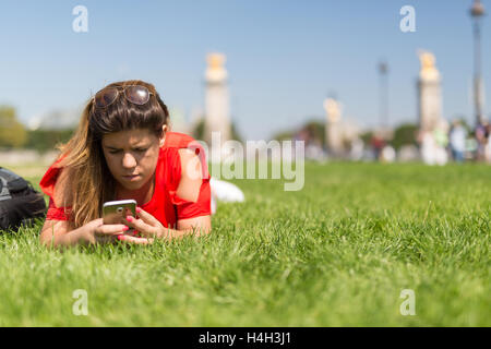 Glückliche Frau in Paris überprüfen ihr Smartphone News Stockfoto