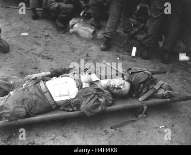 Nach einer Verwundung in der Schlacht bei der Überquerung des Flusses Naktong während des Koreakrieges 19. September 1950 in Korea liegt auf einer Bahre an eine medizinische Hilfe-Station, US Army Soldat Pfc. Thomas Conlon mit der 21. Infanterie-Division. Stockfoto