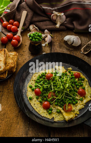 Gesunden Omelette mit Gemüse - Erbsen und Sonnenblumen Microgreens toast Cherry-Tomaten Stockfoto