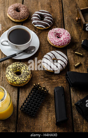 Amerikanische Polizisten Morgen, Donuts, Saft, frischen schwarzen Kaffee und seine Waffe Stockfoto