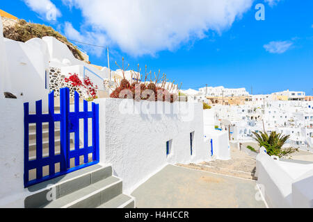 Blauen Tor auf der schmalen Straße und typisch griechischen Häusern im Dorf Imerovigli auf Santorin, Griechenland Stockfoto