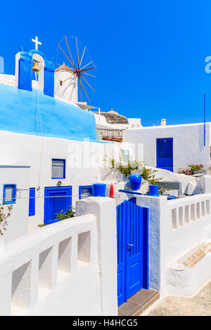 Typische griechische Häuser und Windmühle auf Straße von Dorf Oia, Santorin, Griechenland Stockfoto