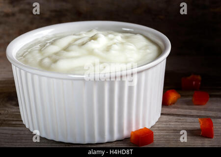 Joghurt in eine weiße Keramikschale auf einem Holztisch Stockfoto