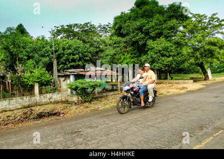 La Maquina, Guatemala – 16. Juni 2011: paar auf einem Motorrad auf einem Feldweg in La Maquina, Guatemala. Nur zur redaktionellen Verwendung. Stockfoto