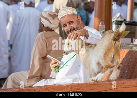 Niawa, Oman, 13. Oktober 2016: Omanischen Mann mit seiner Ziege in Nizwa Markt Stockfoto