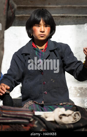 Nomadische weibliche Yak-Herder Spinnerei Yak-Haar an Pele La, einem 3420 m Bergpass zwischen Trongsa und Wangdue Phodrang in Bhutan Stockfoto