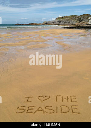 Die Worte 'Ich liebe das Meer' im goldenen gelben Sand der abgelegenen schottischen Strand geschrieben. Stockfoto