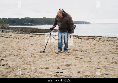 Ein Mann mit einem Metalldetektor arbeiten an Falmouth Gyllyngvase Strand Stockfoto