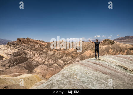 Death Valley und ein glückliche Wanderer stehend auf der Felge mit Armen hochgezogen. Sieger, Leistung und Erfolg-Konzept in der Natur. Stockfoto