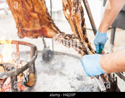 Asado, traditionellen Barbecue-Gericht in Argentinien, gebratenes Fleisch Rindfleisch gekocht auf einem vertikalen Grill um Feuer gelegt Stockfoto