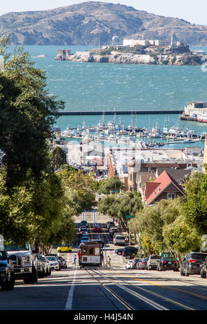 Cable Car an der Hyde Street mit Alcatraz Island im Hintergrund in San Francisco, Kalifornien, USA. Stockfoto