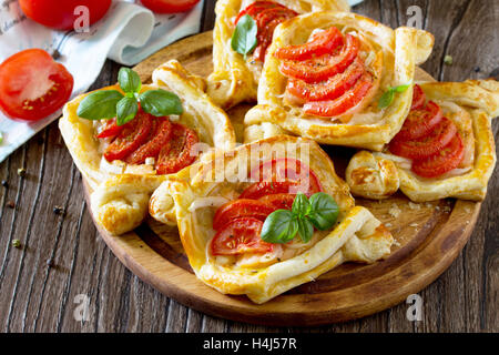 Kuchen mit roter Fisch (Lachs und Blätterteig) und Tomaten auf einem Holztisch. Stockfoto