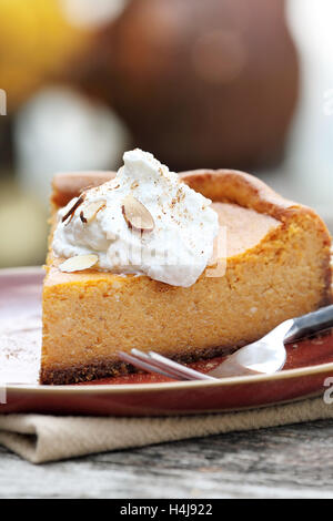 Ein Stück Käsekuchen Kürbiskuchen mit hausgemachten Schlagsahne, Alomonds und Kürbis Gewürz. Extrem geringe Schärfentiefe. Stockfoto