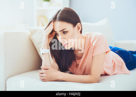 Junge enttäuscht Frau auf dem Sofa zu legen. Stockfoto