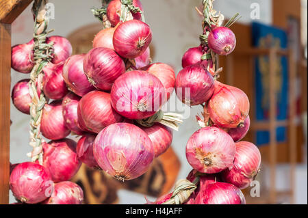 Rote Zwiebel Zöpfen in Italien in den Bauernmarkt verkauft. Stockfoto