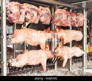 Schlachtkörper von Schweinefleisch und anderen Fleisch am Spieß zubereitet. Kochen am Grill und Feuer. Stockfoto