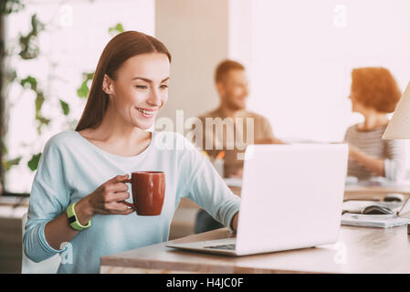 Angenehme lächelnde Frau mit laptop Stockfoto