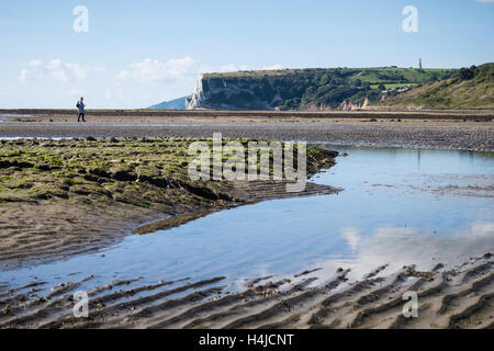 Eine Frau, die zu Fuß auf den Strand in der Nähe von Whitecliff Bay und Vorland in Bembridge auf der Isle of Wight Stockfoto