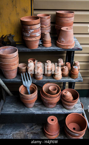 Vintage Terrakotta-Töpfe und eine Vintage-Gartengabel auf einer Gartenbank, Gartengeräte liefert, Vermont, USA, Werkzeugschuppen Terra Cotta-Töpfe stapeln Werkzeug Stockfoto